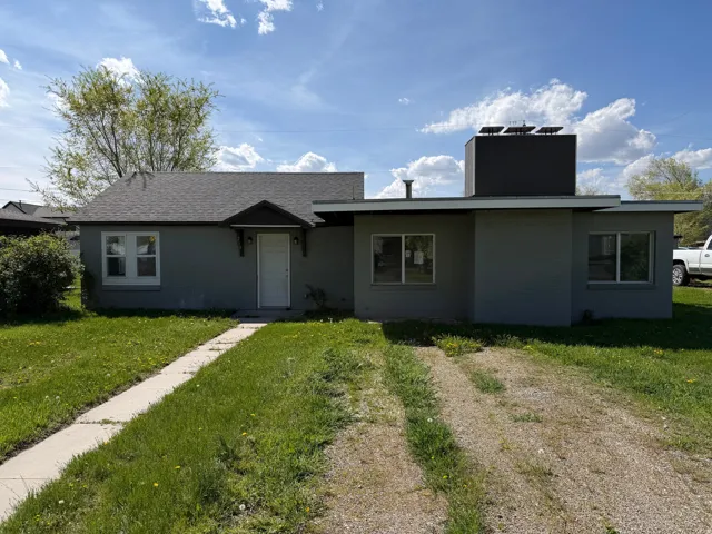 View of front facade with a front yard and a chimney
