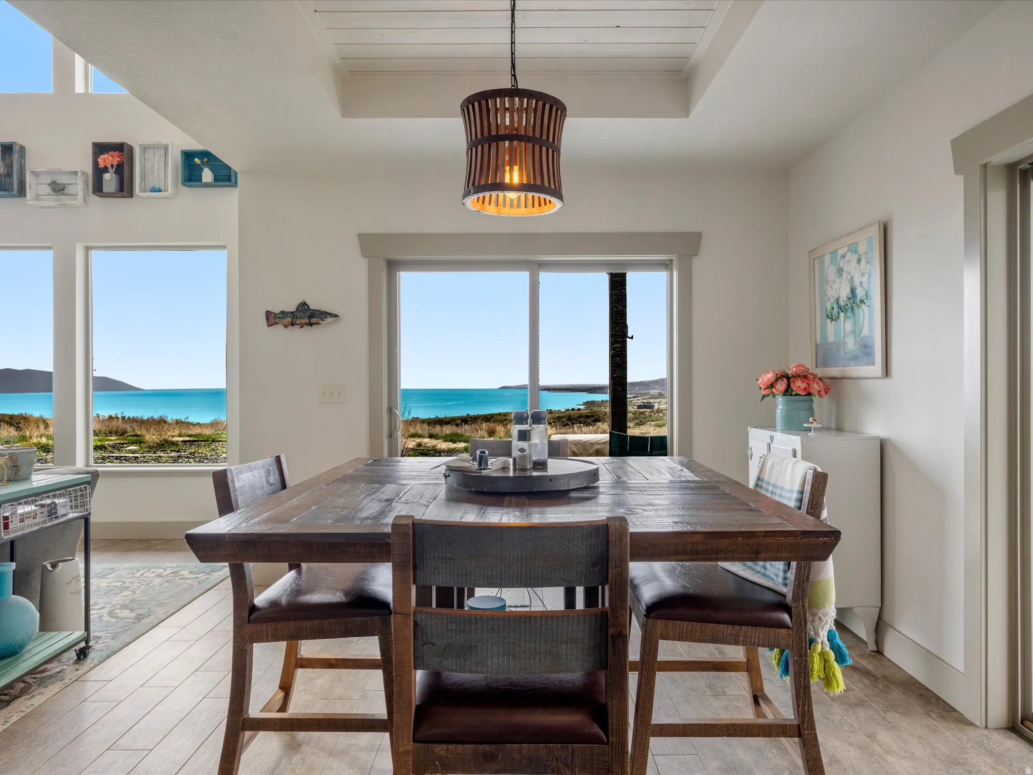 Dining space with a lake view and a tray ceiling