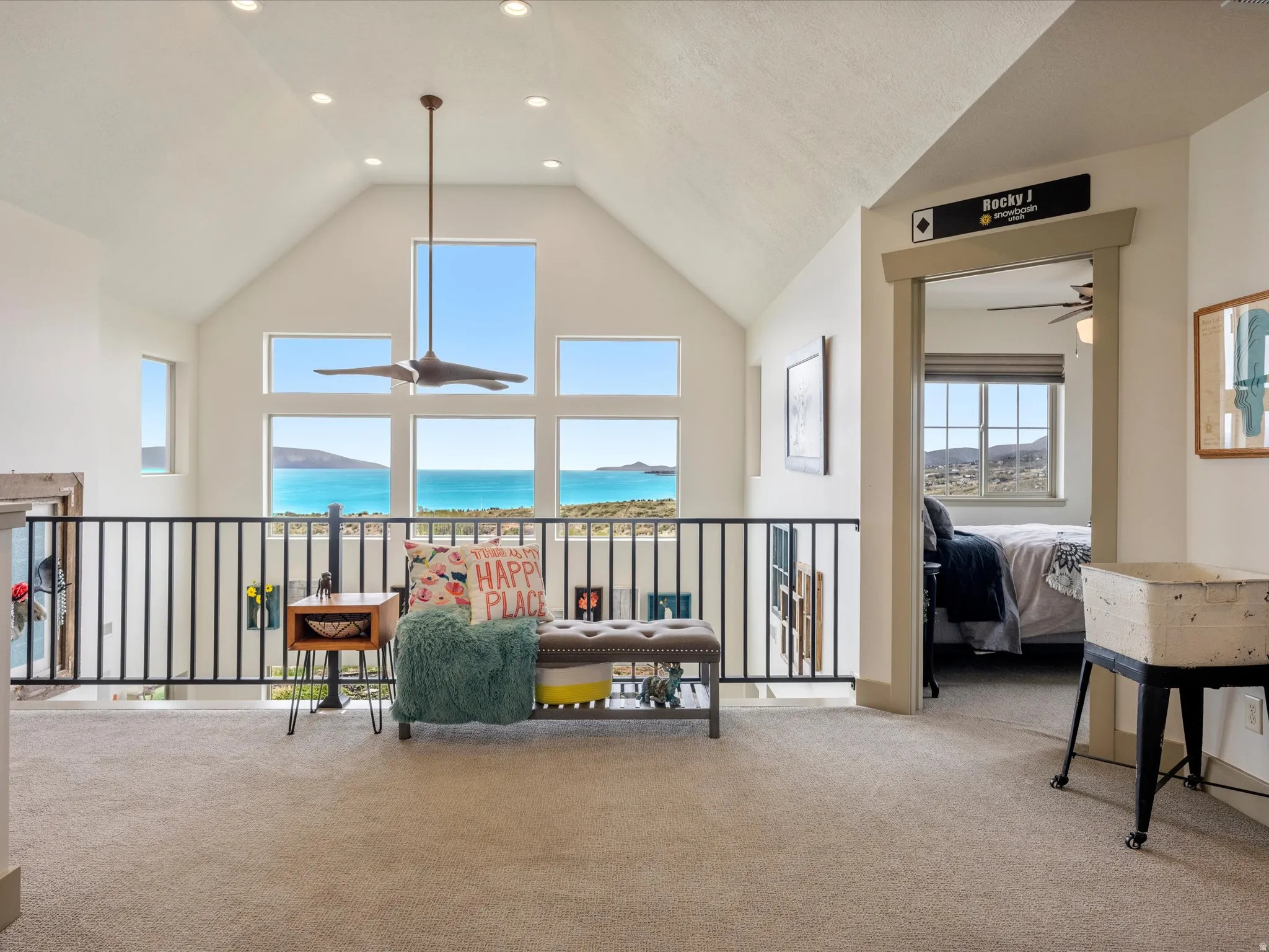 Carpeted living room featuring a lake view and a high ceiling