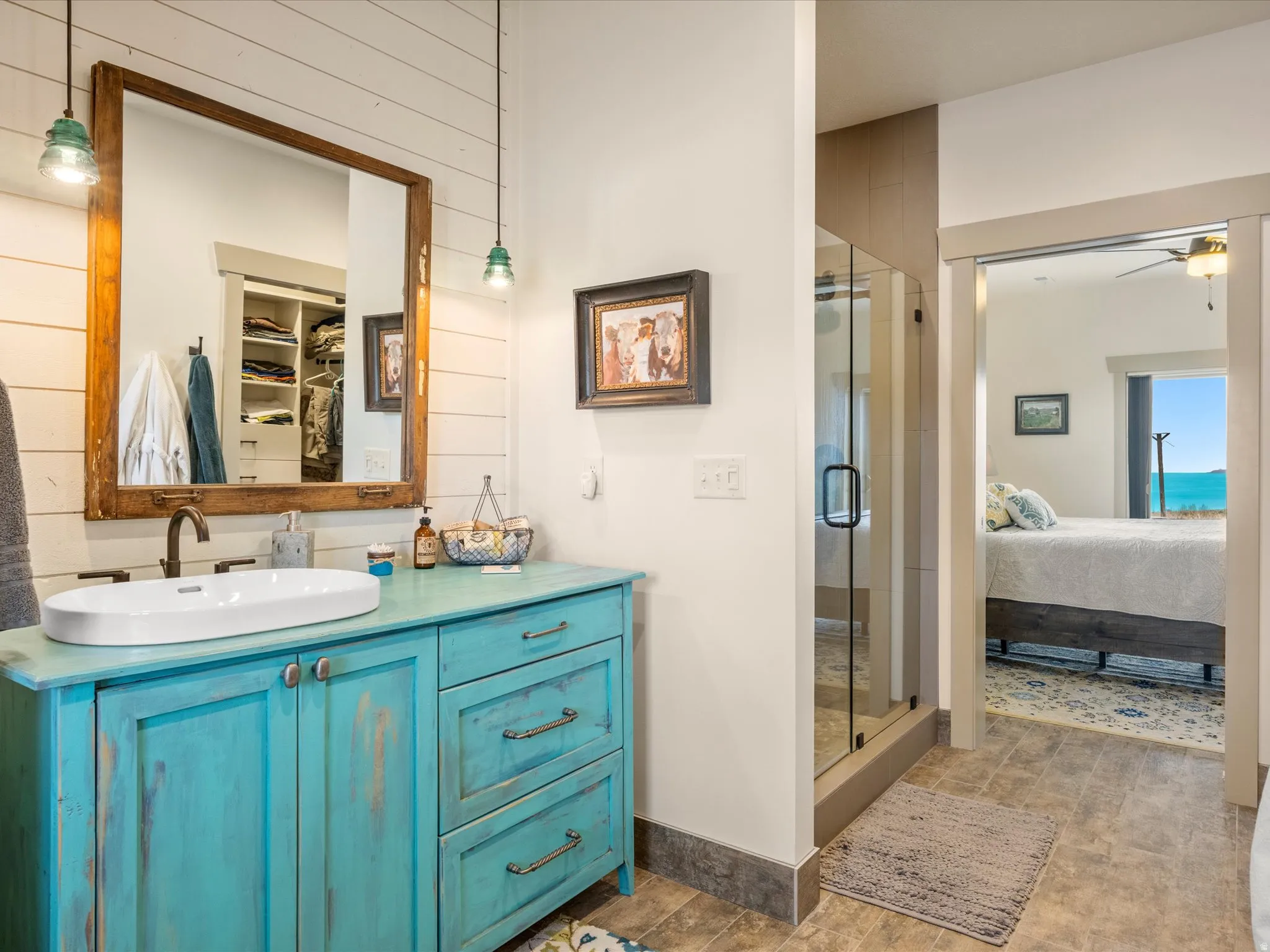 Ensuite bathroom featuring vanity, a shower stall, a spacious closet, and ceiling fan