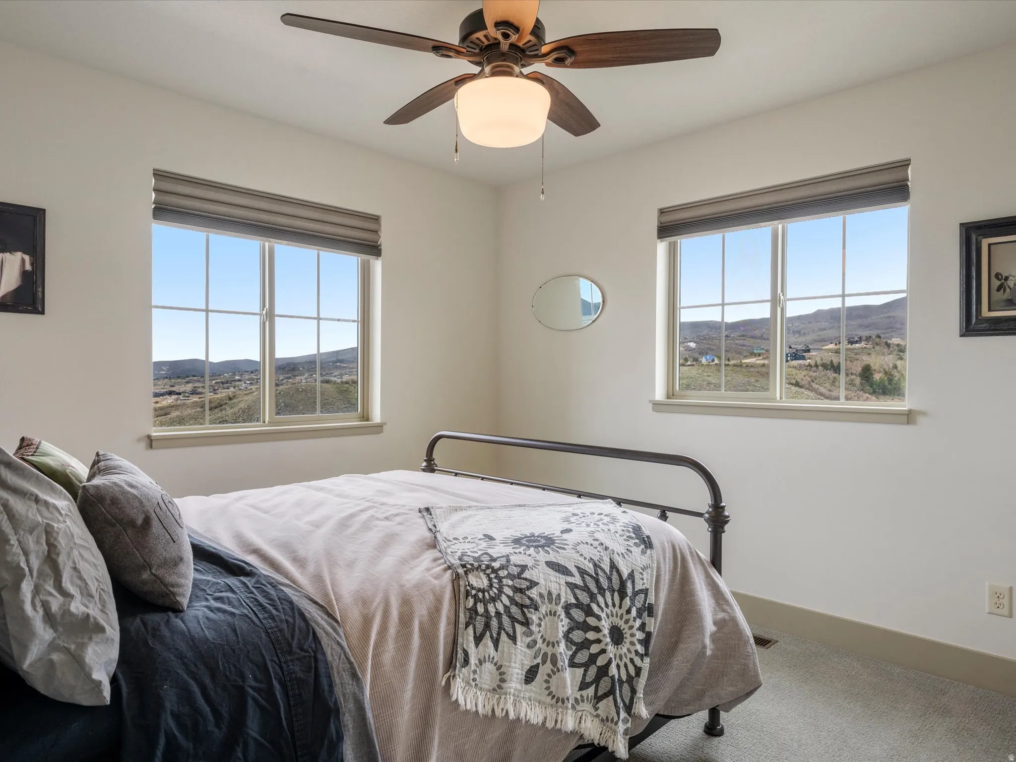 Carpeted bedroom with a mountain view and ceiling fan