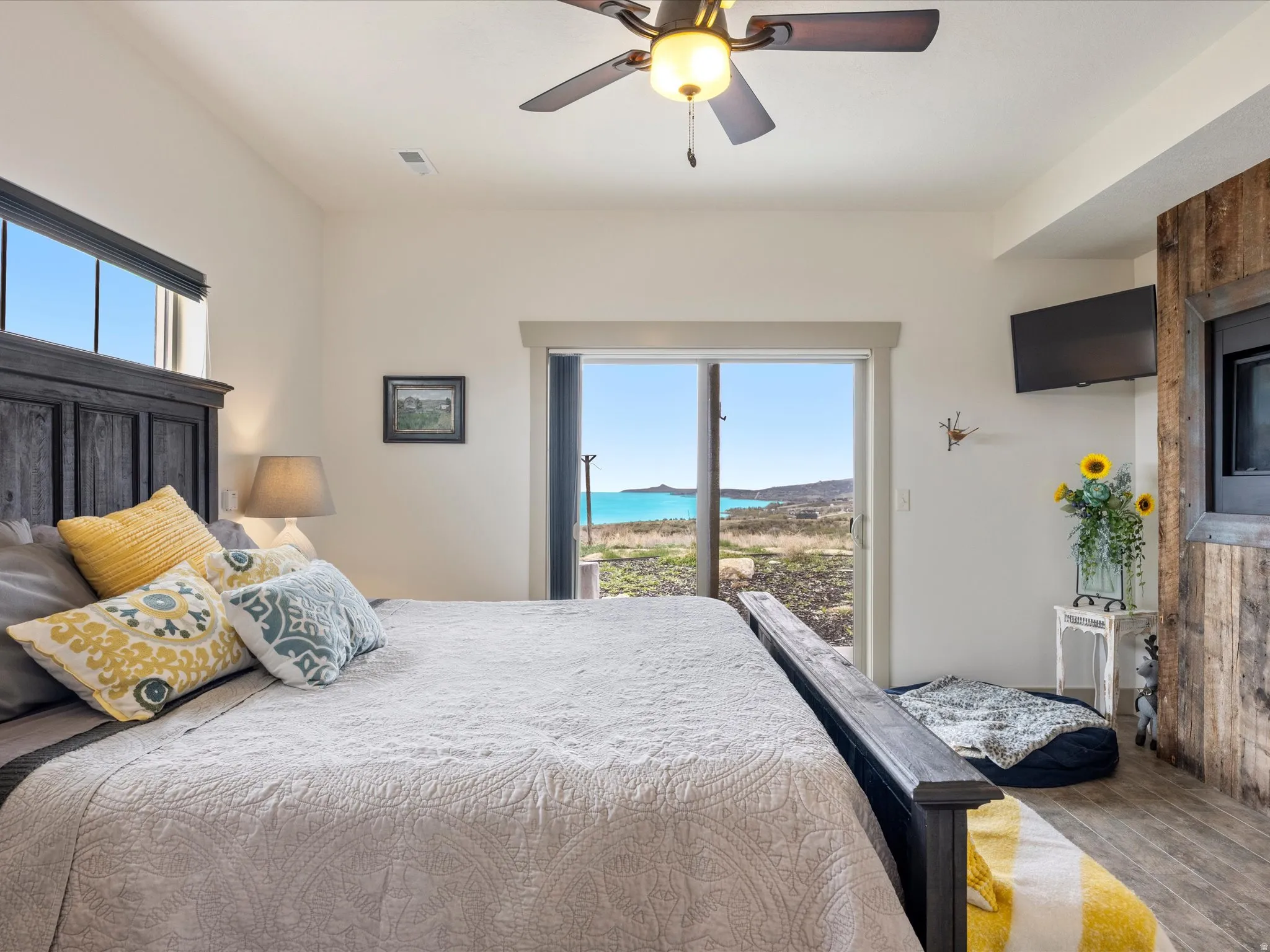 Primary Bedroom with a ceiling fan, wood finished floors, and access to outside