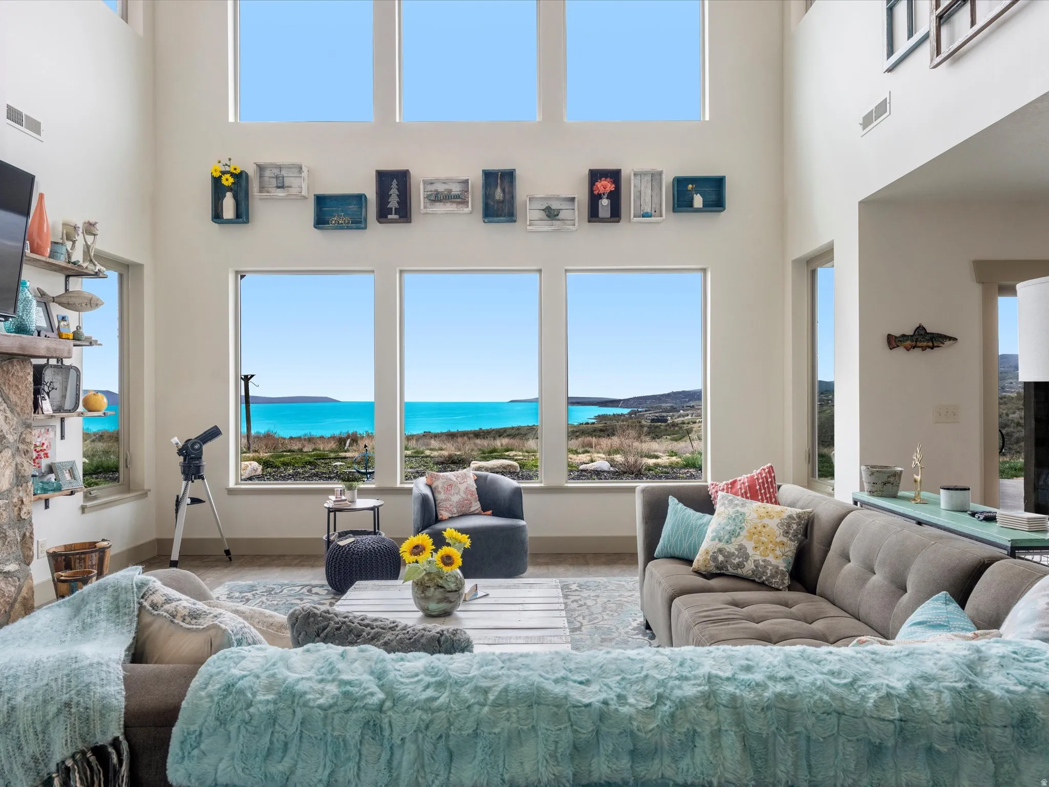 Living room featuring a high ceiling and floor to ceiling windows and a lake view