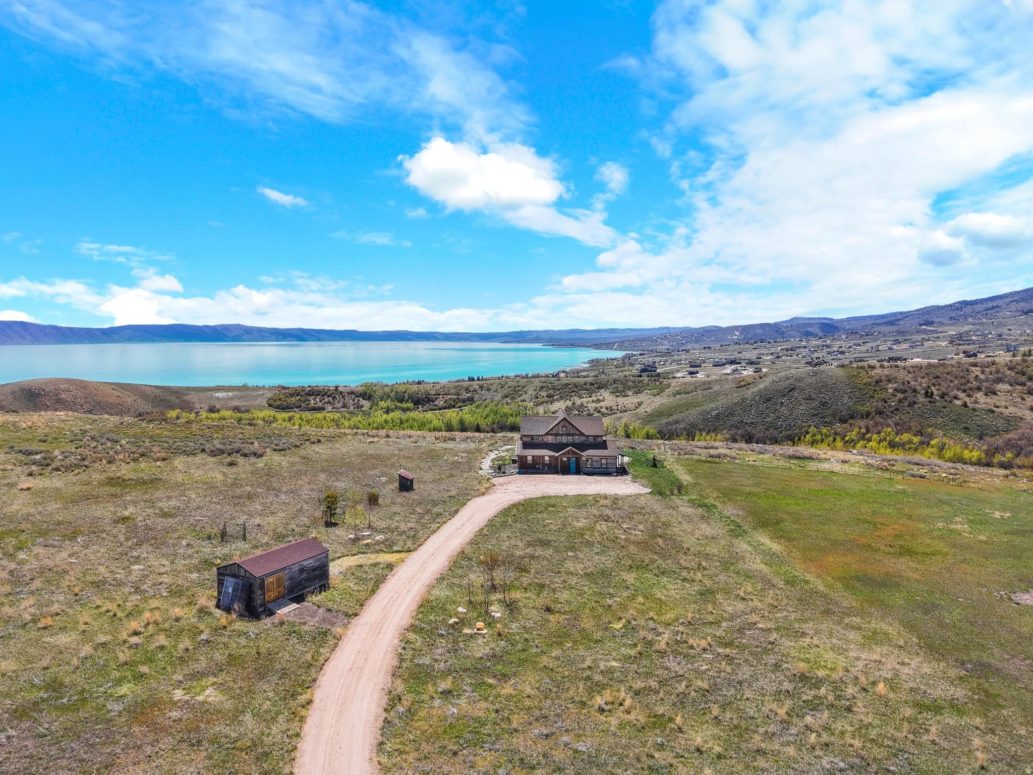Aerial view of property and surrounding area with a water and mountain view