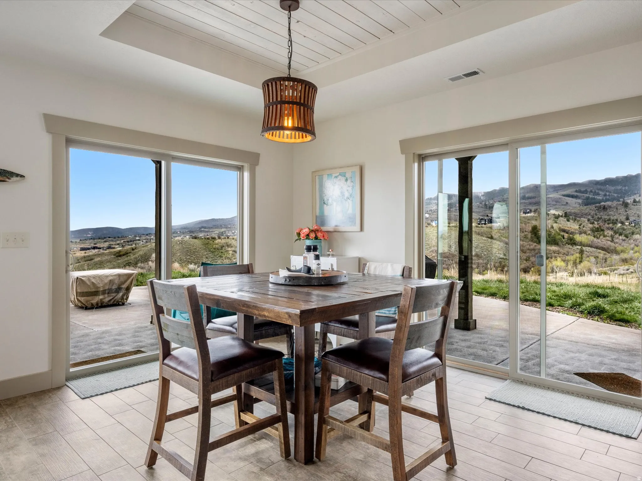 Dining room featuring a mountain view, light wood-type flooring, and a wooden tray ceiling