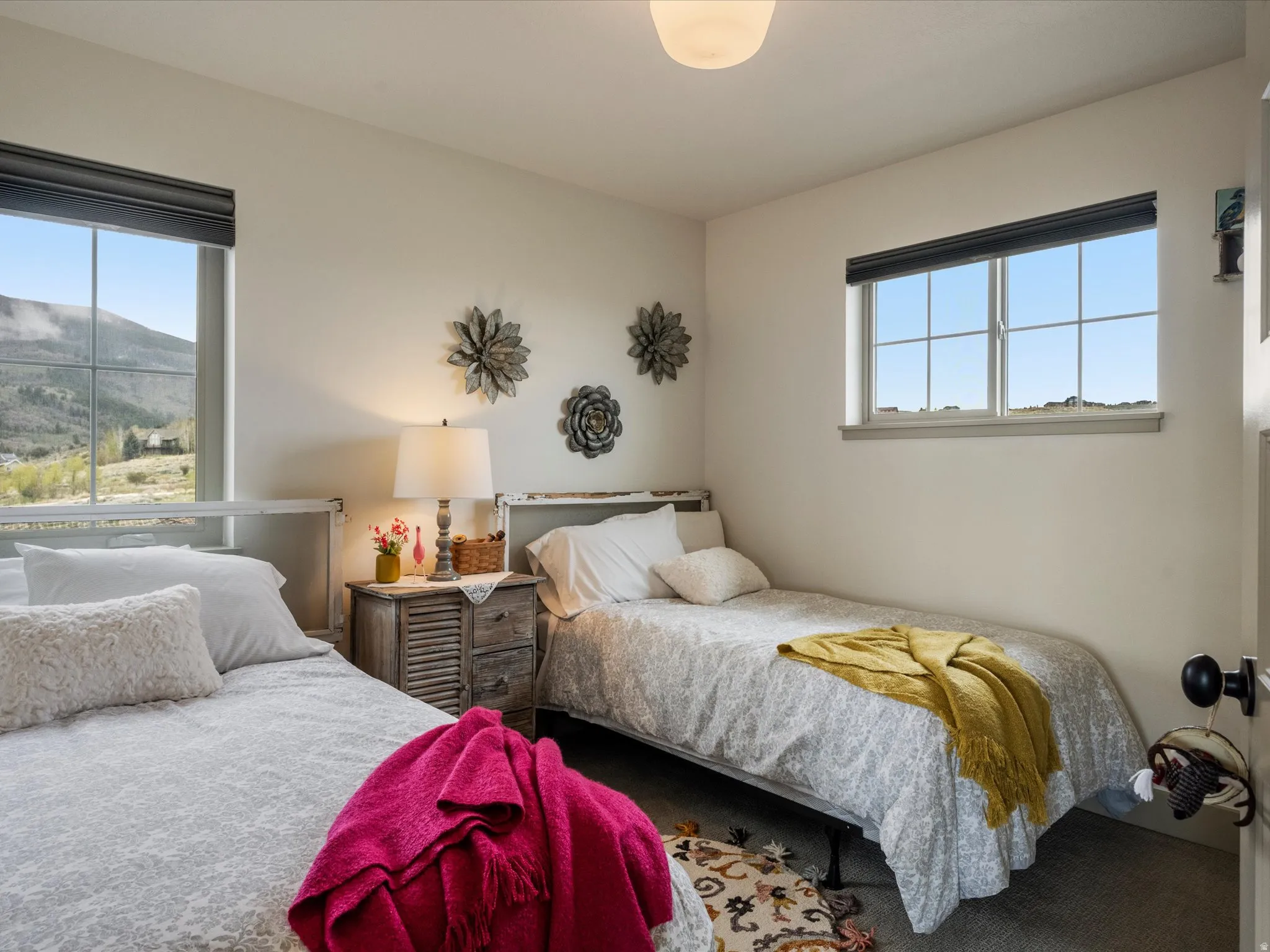 Carpeted bedroom with a mountain view and multiple windows