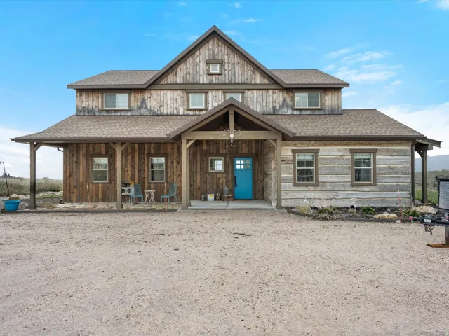 View of front facade featuring a shingled roof and a porch