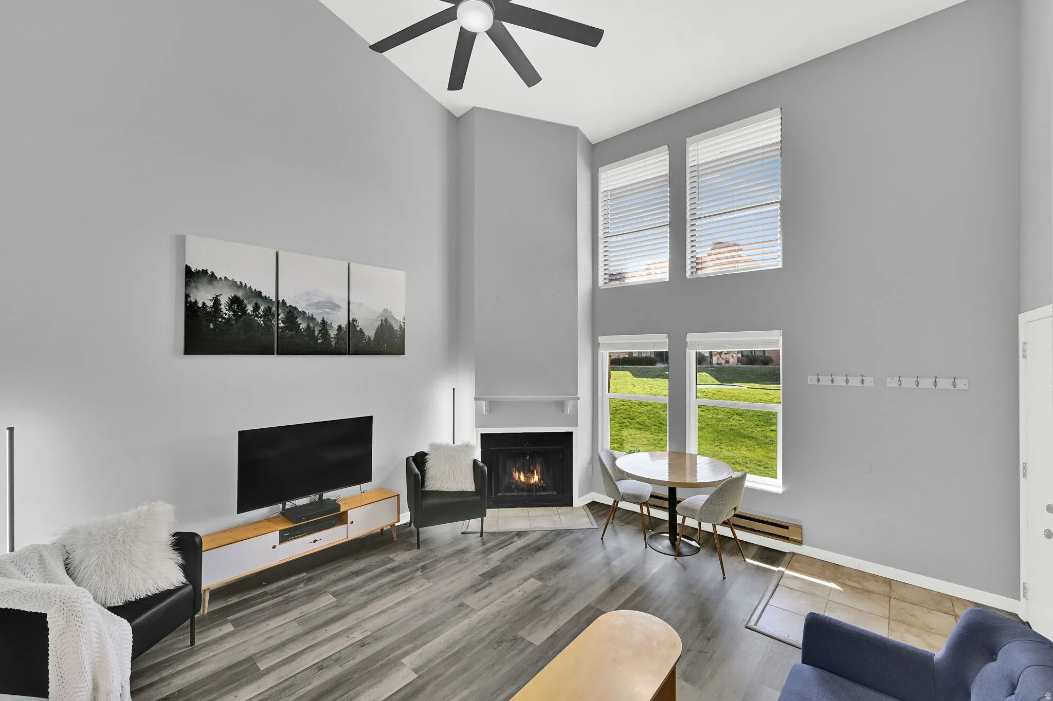 Lofted living room with upgraded, neutral LVP flooring, wood burning fireplace and modern finishes. New windows let in natural light.
