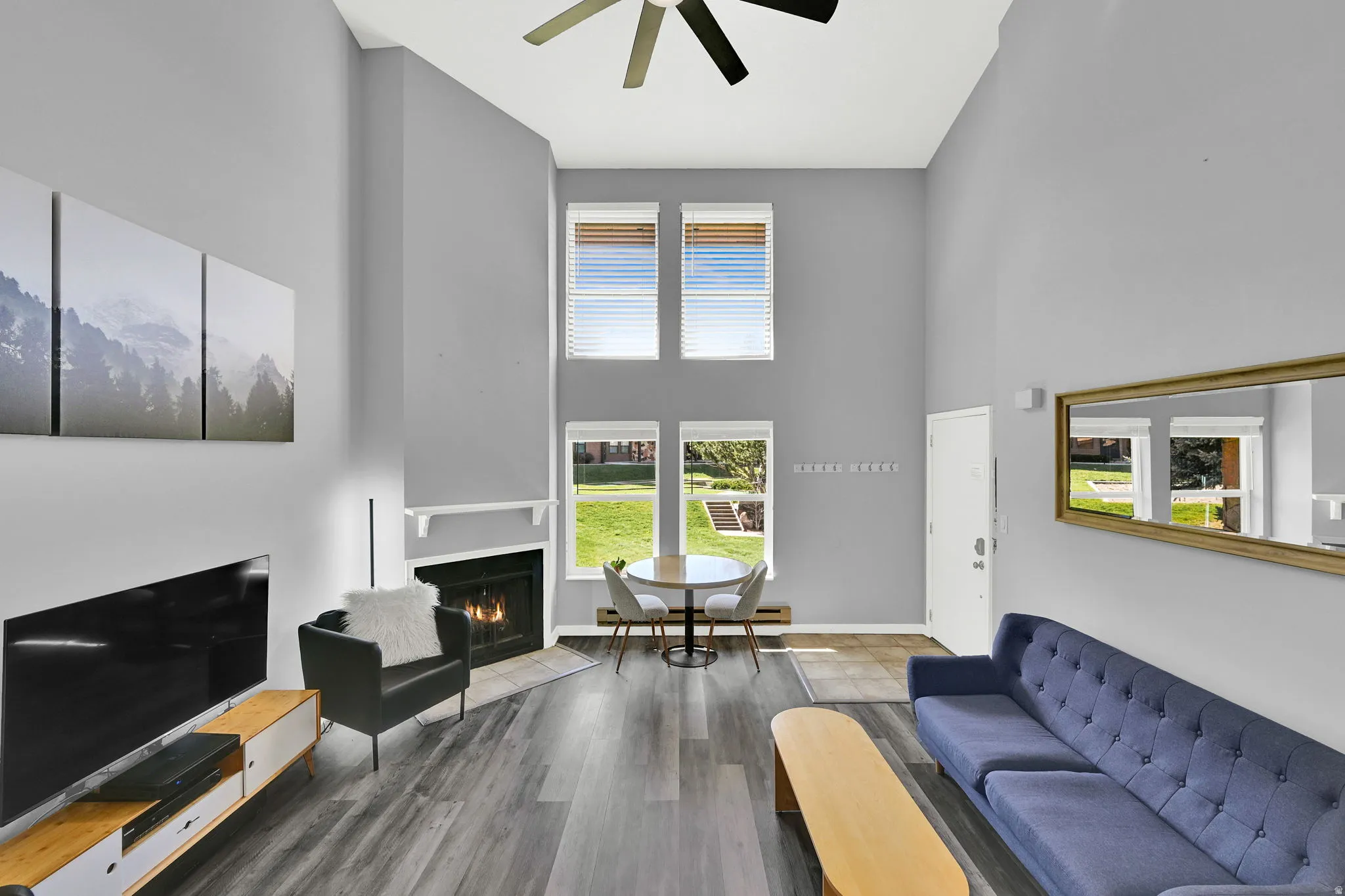 Lofted living room with upgraded, neutral LVP flooring, wood burning fireplace and modern finishes. New windows let in natural light.
