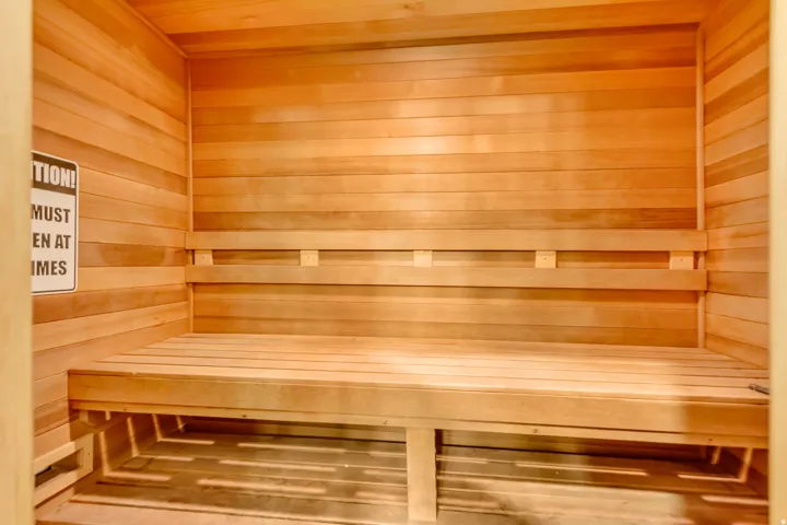 Relaxing sauna featuring wooden walls and wooden ceiling