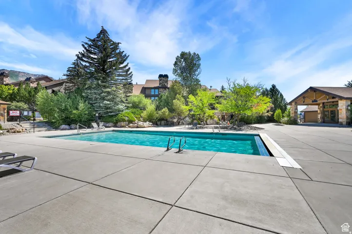 Community pool with a patio and a residential view