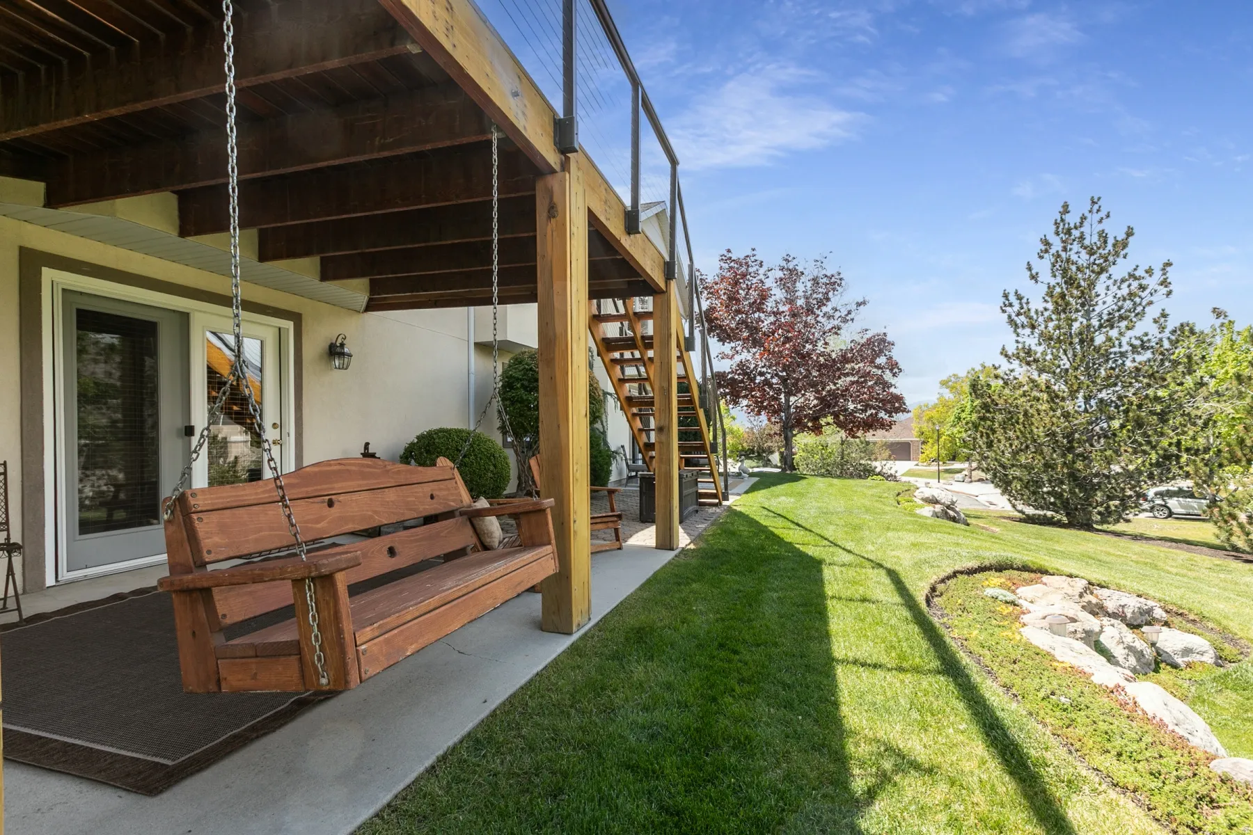 View of grassy yard featuring a patio area, a wooden deck