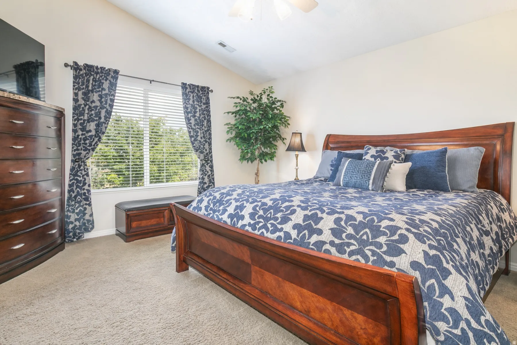 Primary Bedroom with light carpet, lofted ceiling, and a ceiling fan