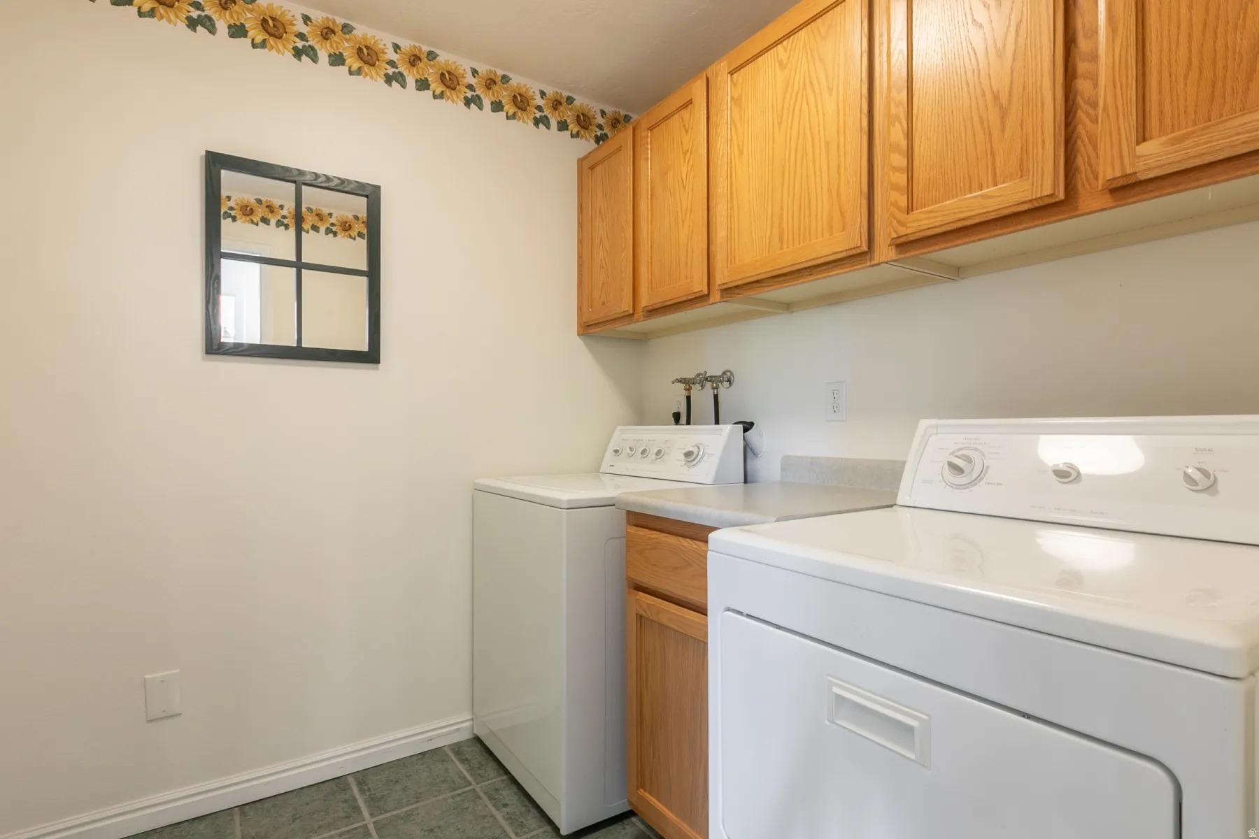 Laundry room featuring washing machine and clothes dryer, cabinet space.