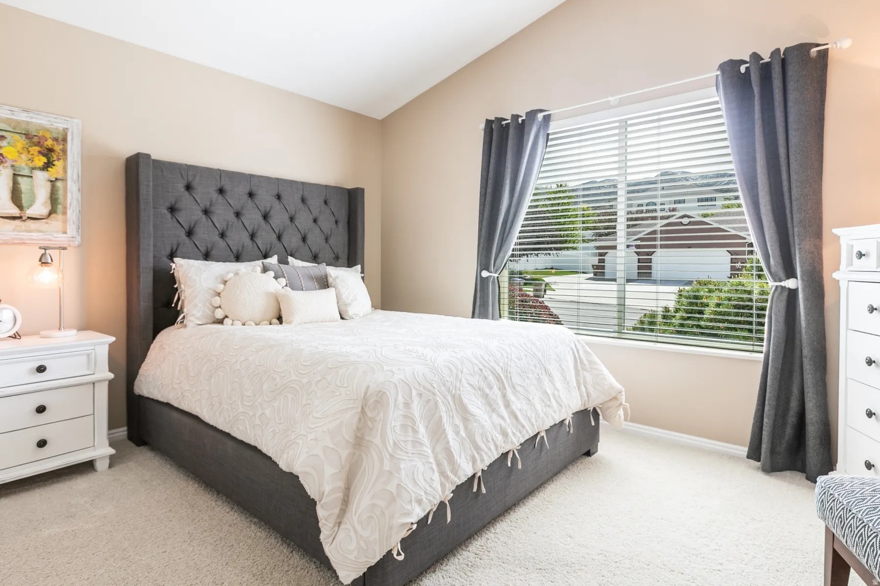 Bedroom with light colored carpet and lofted ceiling