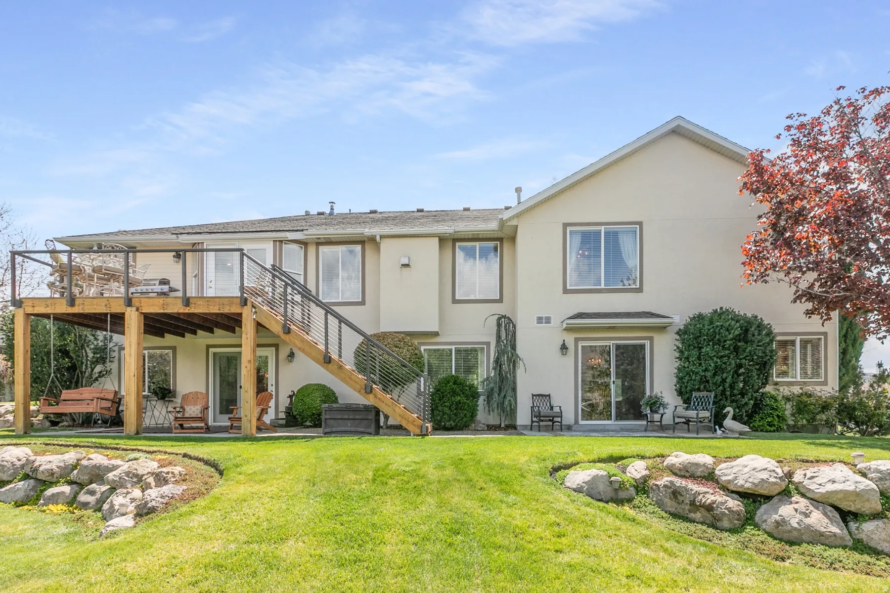 Back of house featuring a patio, stucco siding, and a wooden deck