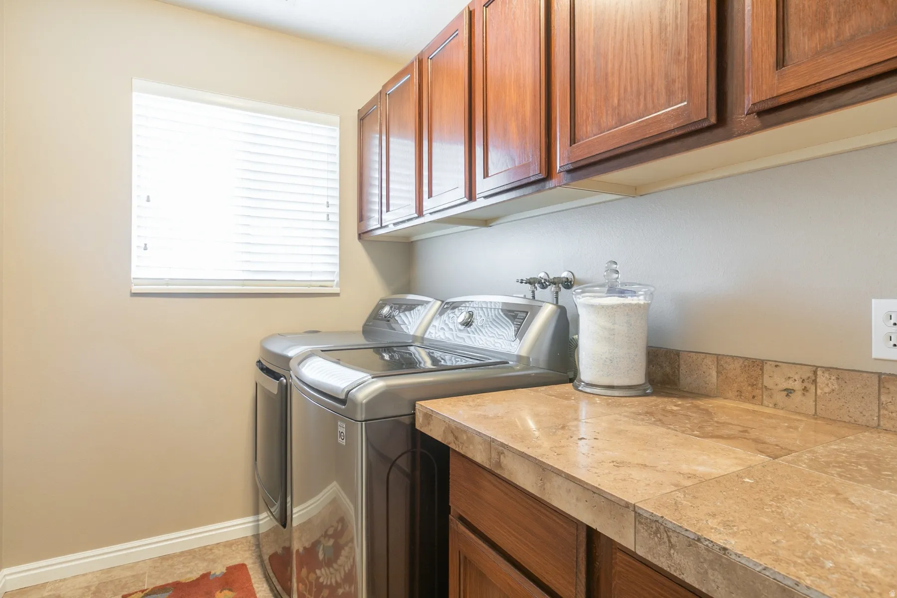 Laundry area with separate washer and dryer and cabinet space