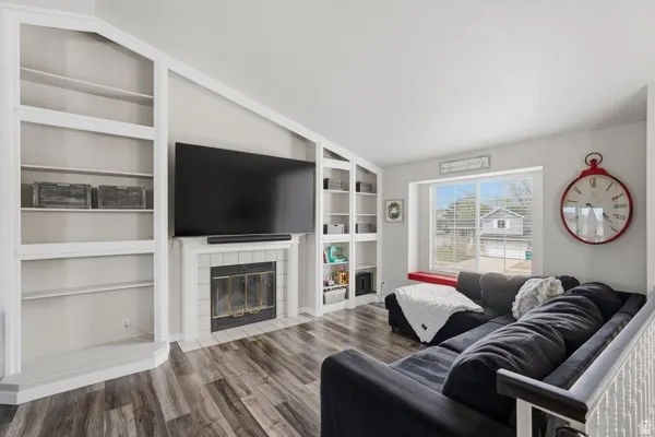 Living area featuring a fireplace, wood finished floors, and built in shelves