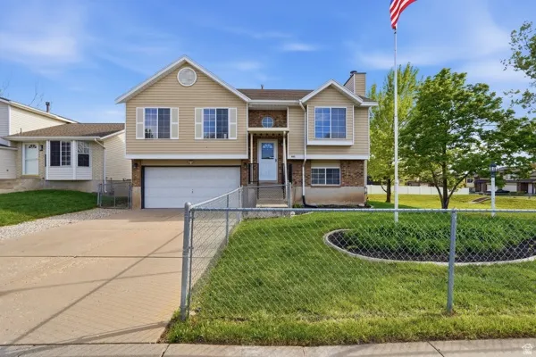 View of front of property featuring concrete driveway, a garage, brick siding, and a chimney