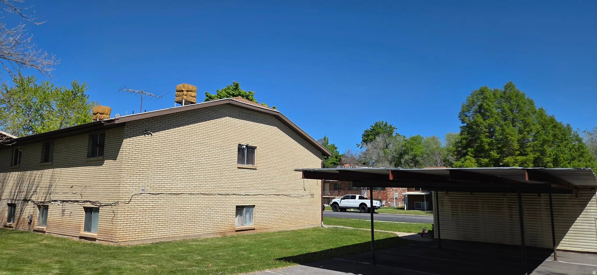 View of side of property featuring a yard and brick siding