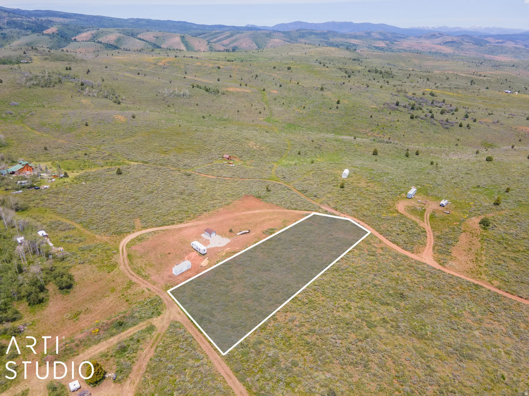 Aerial view of sparsely populated area featuring a mountain backdrop and property boundaries highlighted