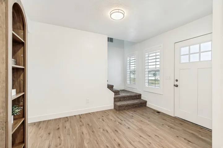 Foyer featuring stairs and light wood finished floors