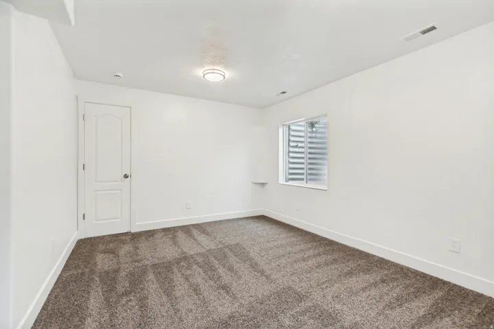 Empty room with baseboards and dark carpet