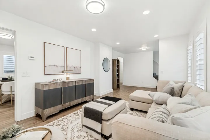 Living area featuring light wood-style flooring, recessed lighting, and arched walkways