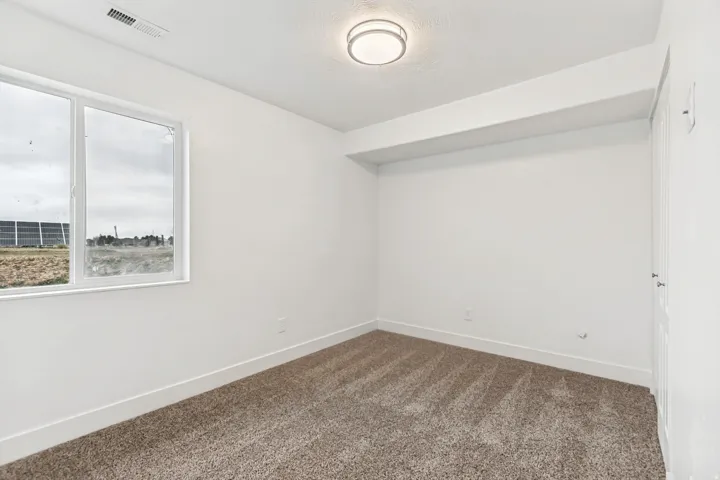 Unfurnished room with baseboards and dark carpet