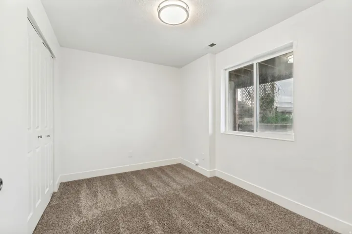 Unfurnished bedroom with dark colored carpet and a closet