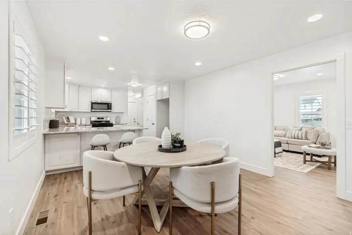 Dining room with light wood finished floors and recessed lighting