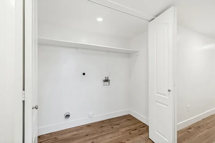 Laundry area with light wood-style flooring, hookup for an electric dryer, washer hookup, hookup for a gas dryer, and recessed lighting