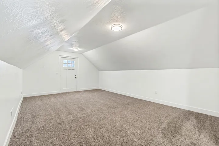 Additional living space featuring carpet floors and a textured ceiling