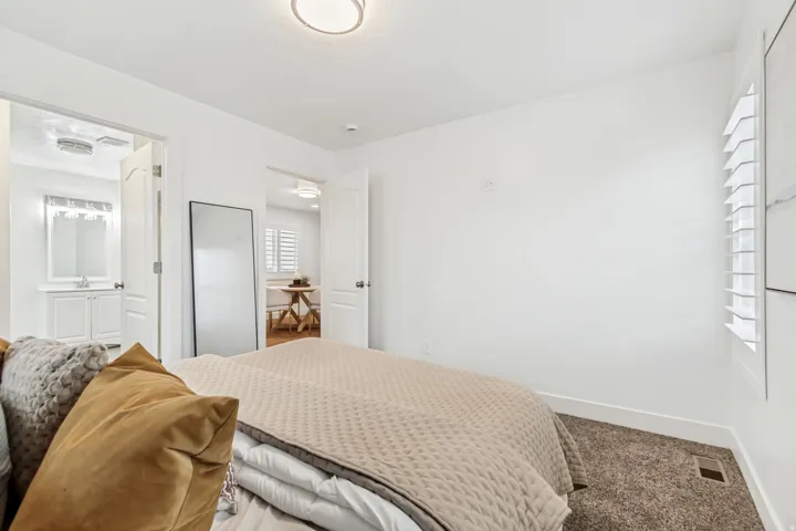 Carpeted bedroom featuring baseboards and ensuite bathroom