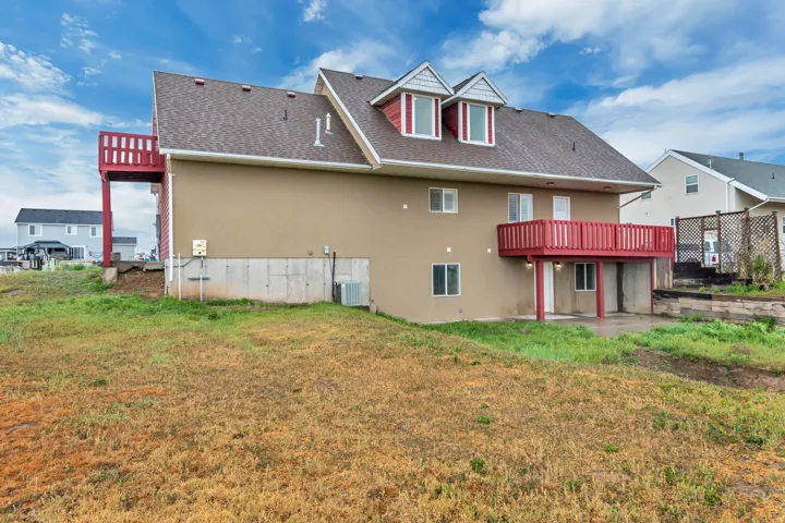 Back of property with roof with shingles, a patio, and a yard