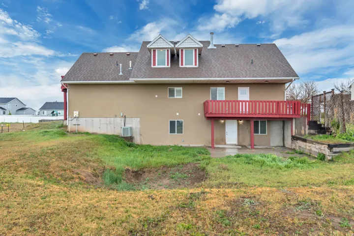 Back of property with a patio, a shingled roof, and stucco siding