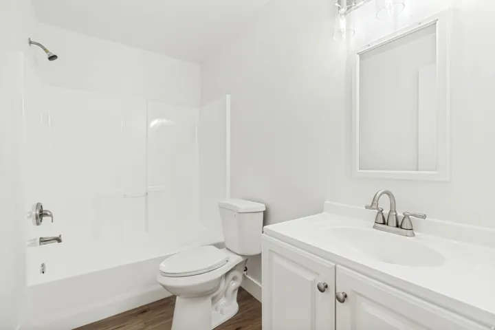 Bathroom featuring vanity, dark wood-type flooring, and tub / shower combination