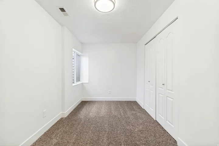 Unfurnished bedroom featuring dark carpet, a closet, and a textured ceiling