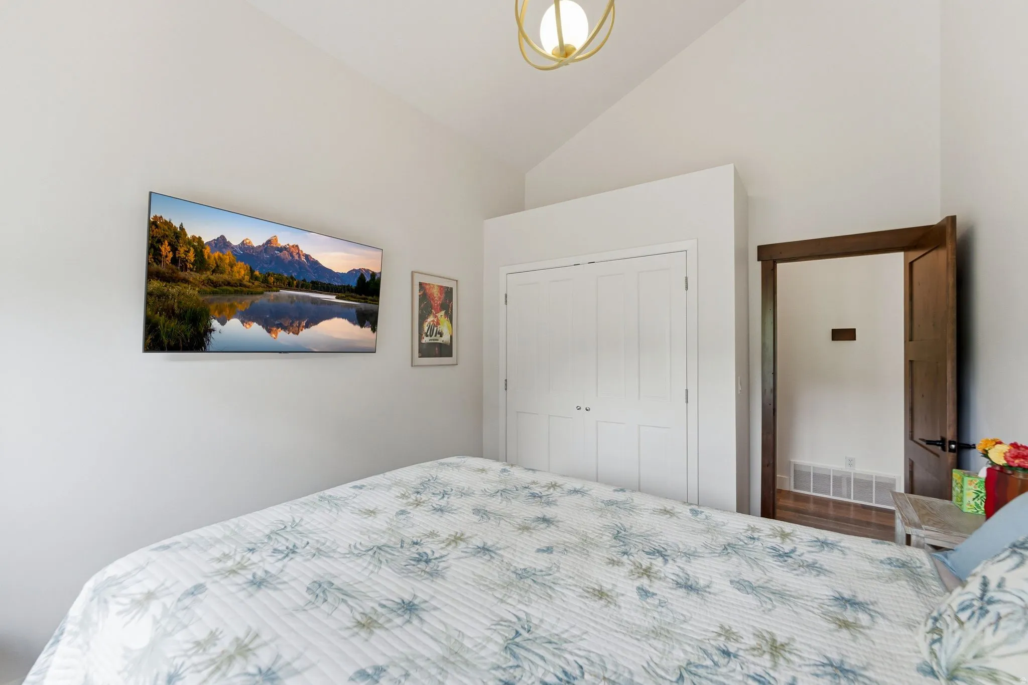 Bedroom with lofted ceiling and a closet