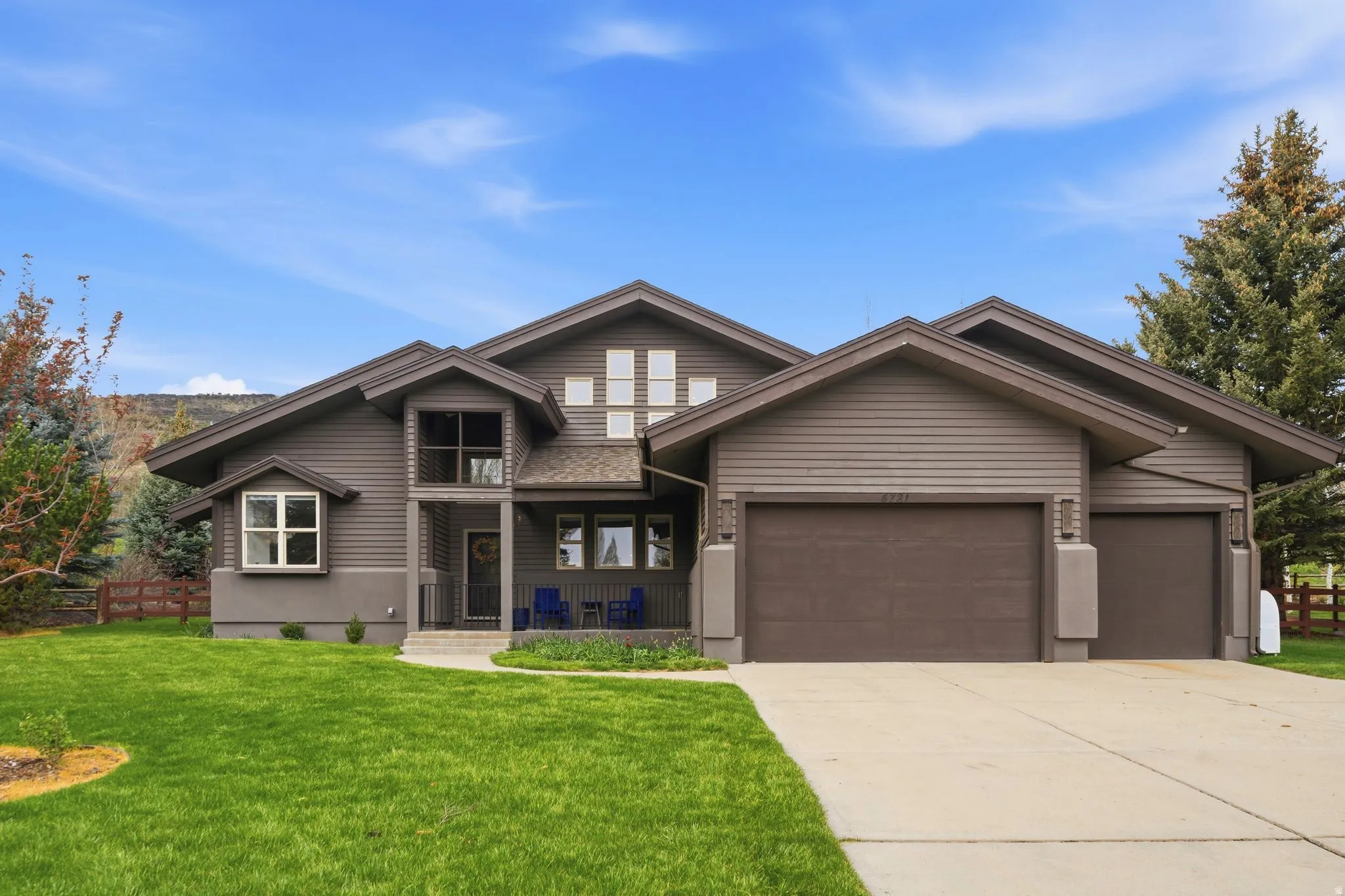 View of front of house with an attached garage, a porch, and driveway