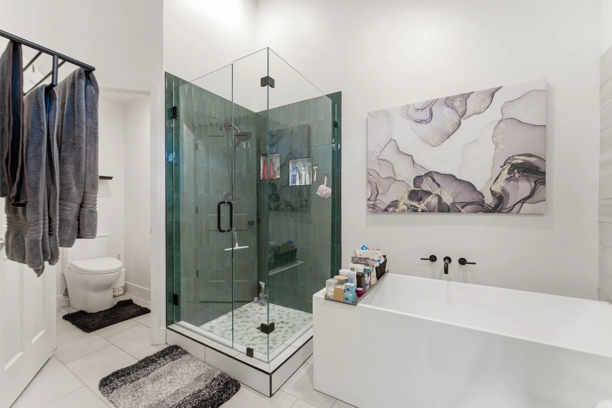 Bathroom with a freestanding bath, a shower stall, and light tile patterned floors