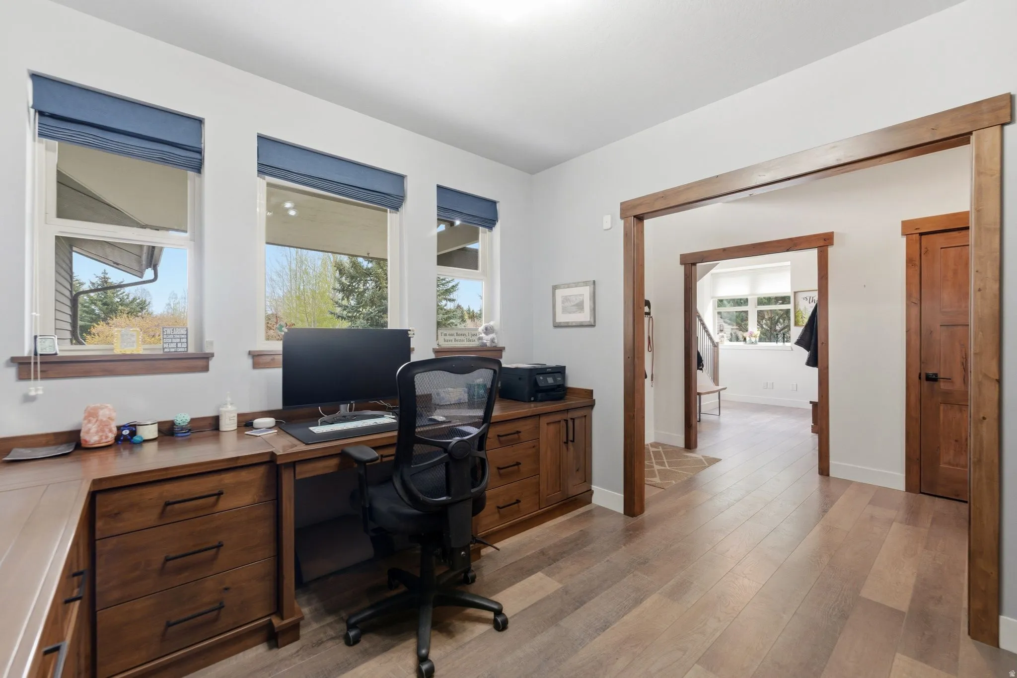 Home office with light wood finished floors and baseboards