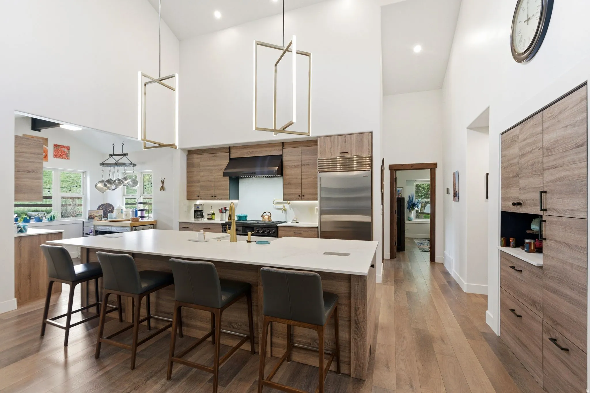 Kitchen featuring modern cabinets, a kitchen breakfast bar, wood finish cabinets, an island with sink, and built in refrigerator
