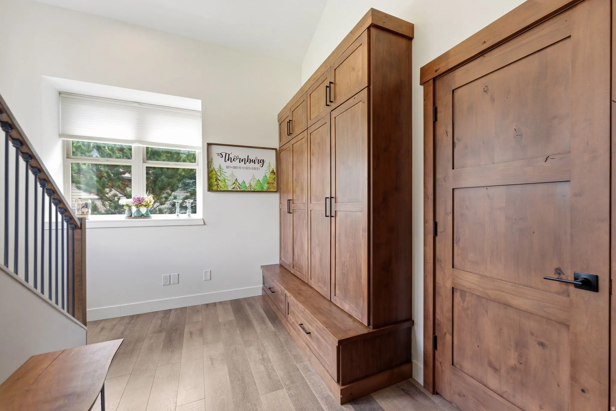Mudroom featuring light wood-style flooring and baseboards