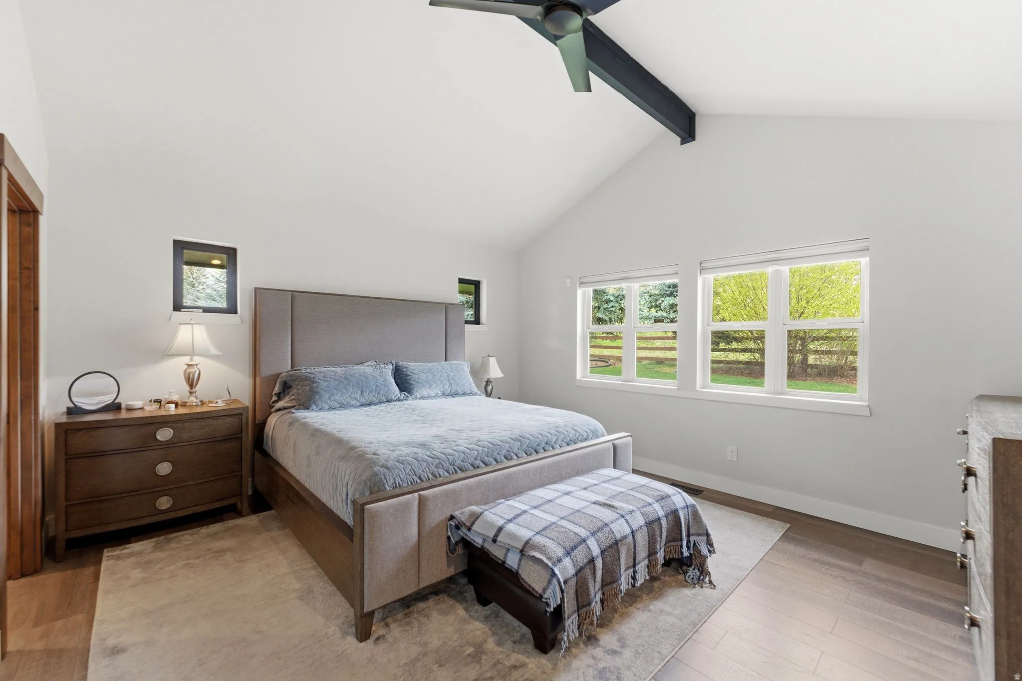 Bedroom featuring beam ceiling, light wood-style flooring, and a ceiling fan
