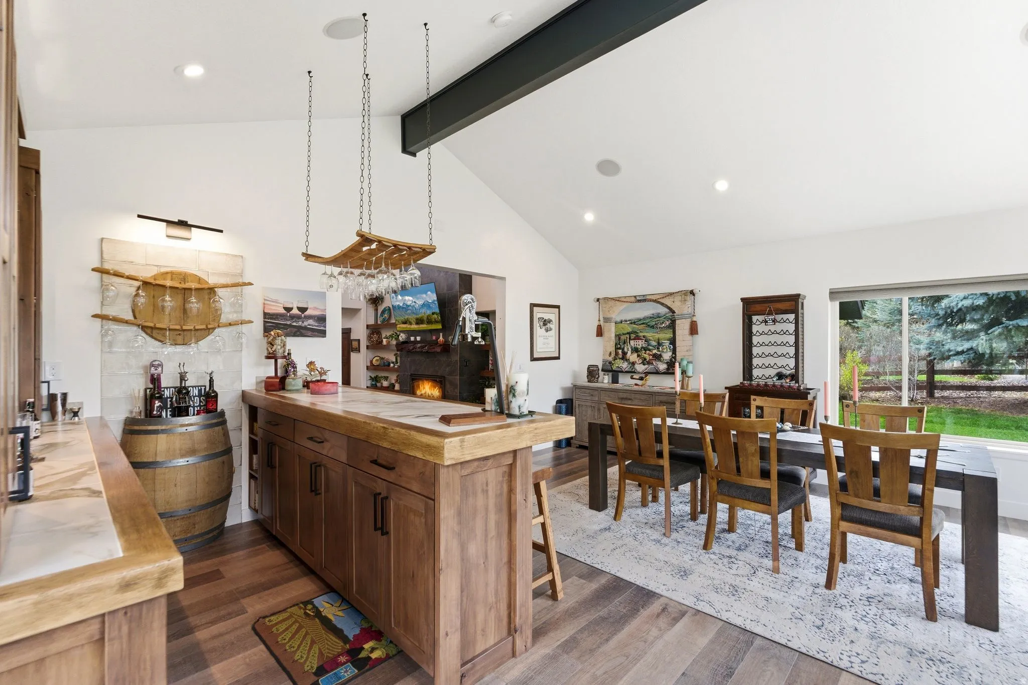 Kitchen featuring butcher block counters, a peninsula, recessed lighting, dark wood finished floors, and a warm lit fireplace