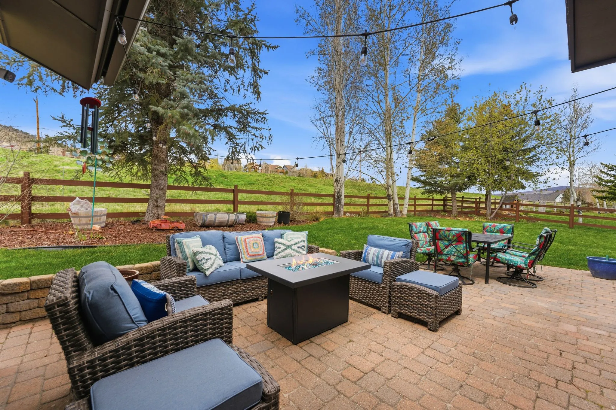 Fenced backyard with an outdoor fire pit, a patio, and an outdoor living / dining area