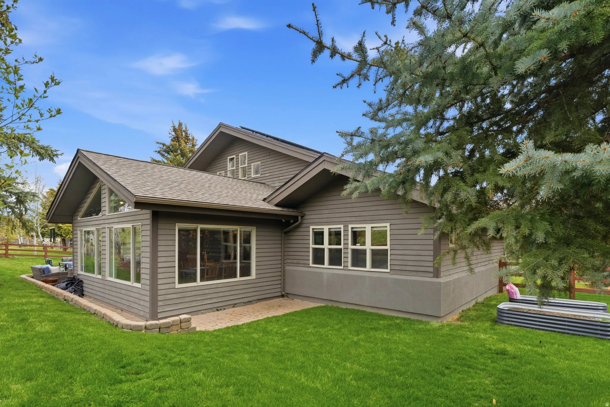 Rear view of house featuring a yard and roof with shingles