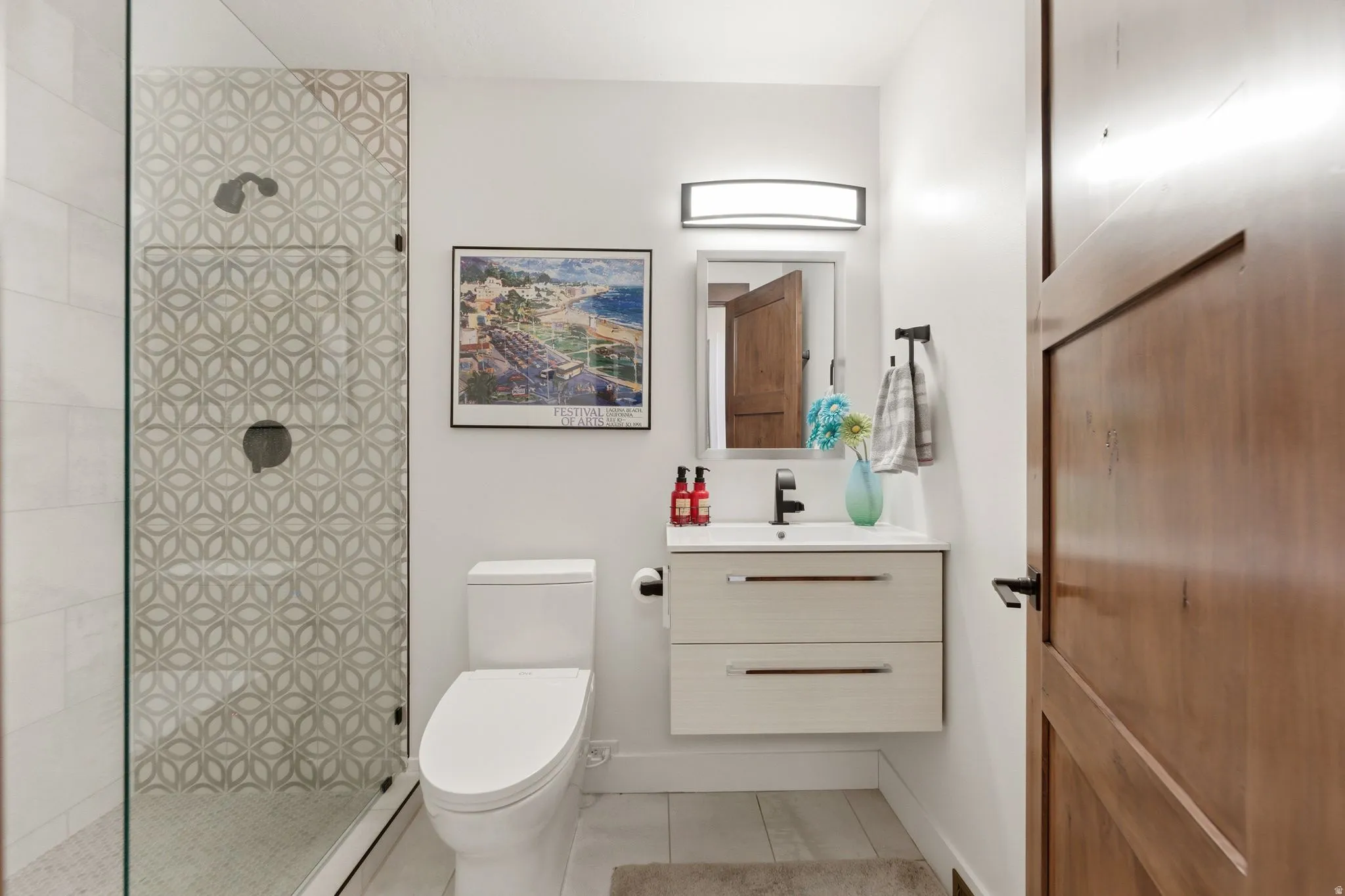 Full bath with vanity, a walk in shower, and light tile patterned flooring