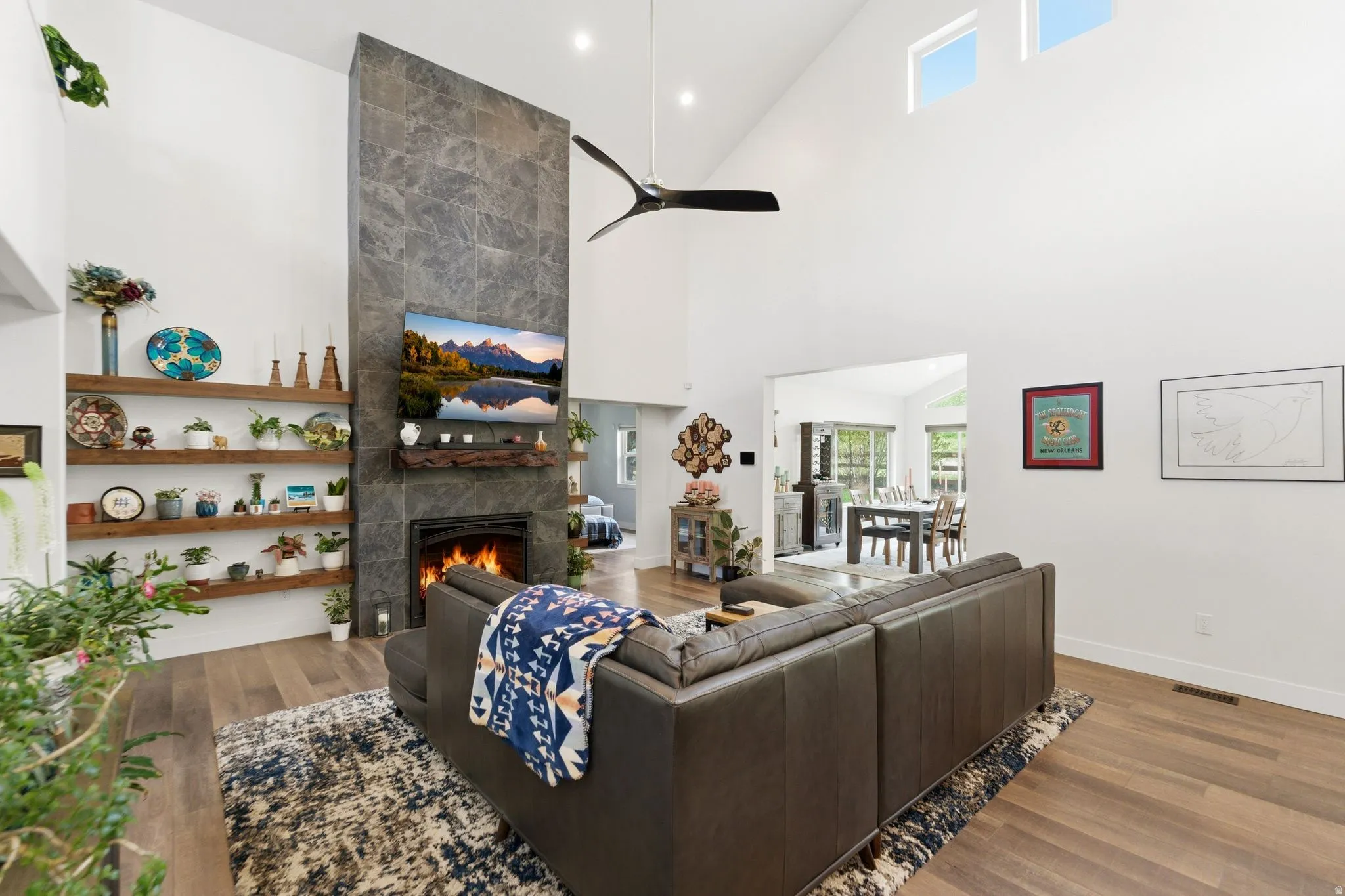 Living area with wood finished floors, a tile fireplace, lofted ceiling, a ceiling fan, and recessed lighting